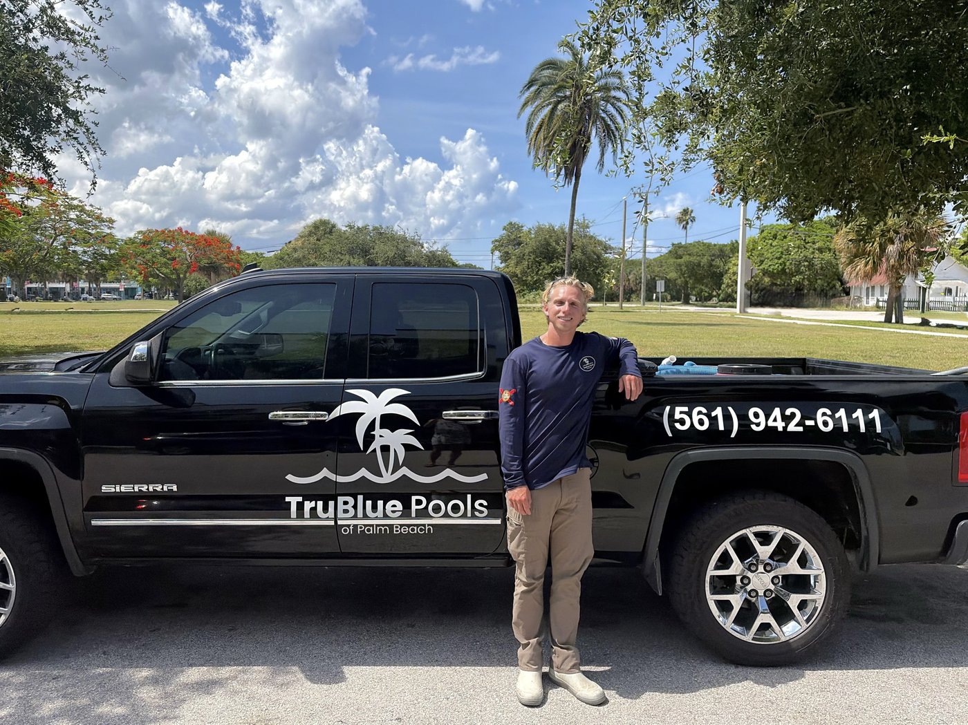 Jonah Robertson, owner and operator of TruBlue Pools of Palm Beach, standing beside the company truck